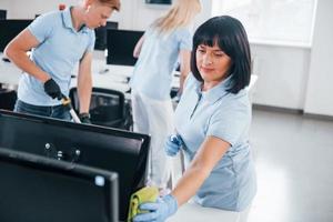 reinigt monitor. groep van arbeiders schoon modern kantoor samen Bij dag foto