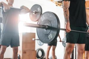 hijs- halter. groep van jong sportief mensen hebben crossfit dag binnenshuis in Sportschool foto