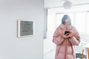 probleem met temperatuur. vrouw is binnenshuis controlerend slim huis technologie foto