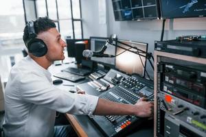 instelling de apparatuur. jong Mens is binnenshuis in de radio studio is bezig door uitzending foto