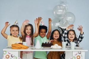 vakantie taart. kinderen Aan vieren verjaardag partij binnenshuis hebben pret samen foto