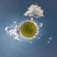 groen klein planeet in blauw lucht met mooi wolken met transformatie van bolvormig panorama 360 graden. kromming van ruimte. foto