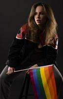lesbienne vrouw Holding regenboog vlag geïsoleerd Aan zwart achtergrond. lgbt Internationale symbool van de lesbienne, homo, biseksueel en transgender gemeenschap. foto