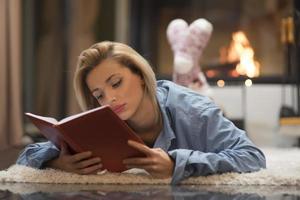 blond Dames door een brand plaats lezing een boek. leven stijl concept foto