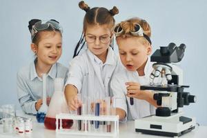 test buizen met kleurrijk vloeistof. kinderen in wit jassen Toneelstukken een wetenschappers in laboratorium door gebruik makend van uitrusting foto