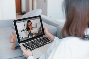 twee jong Dames hebben online gesprek door gebruik makend van tablet foto