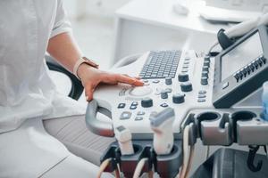 professioneel vrouw kliniek arbeider in wit jas is binnenshuis in de kabinet foto