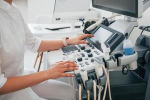 professioneel vrouw kliniek arbeider in wit jas is binnenshuis in de kabinet foto