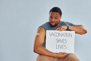 vaccinatie bespaart leeft spandoek. jong Afrikaanse Amerikaans Mens na vaccin injectie foto