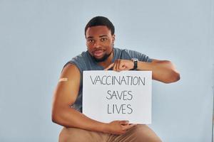 vaccinatie bespaart leeft spandoek. jong Afrikaanse Amerikaans Mens na vaccin injectie foto