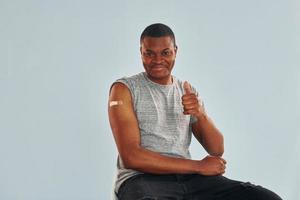 jong Afrikaanse Amerikaans Mens na vaccin injectie is binnenshuis foto