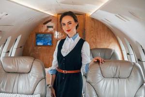 jong stewardess Aan de werk in de passagier vliegtuig foto