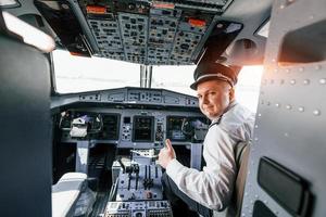 looks achter. piloot Aan de werk in de passagier vliegtuig. voorbereidingen treffen voor uittrekken foto