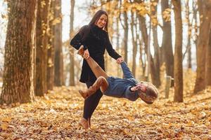 actief weekend tijd besteden. moeder met haar zoon is hebben pret buitenshuis in de herfst Woud foto