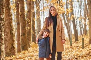 vrolijk vrouw en jongen. moeder met haar zoon is hebben pret buitenshuis in de herfst Woud foto