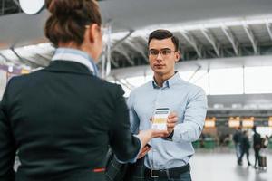 controle documenten. jong zakenman in formeel kleren is in de luchthaven Bij dag foto