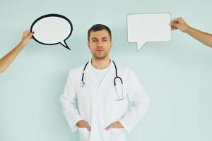 in dokter uniform. Mens staand in de studio met leeg tekens voor de tekst foto