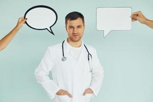 in dokter uniform. Mens staand in de studio met leeg tekens voor de tekst foto