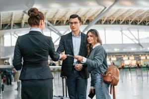 geven de documenten. jong paar is in de luchthaven samen foto