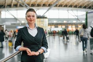 vrouw luchthaven arbeider in formeel kleren is staand binnenshuis foto