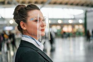 kant visie. vrouw luchthaven arbeider in formeel kleren is staand binnenshuis foto