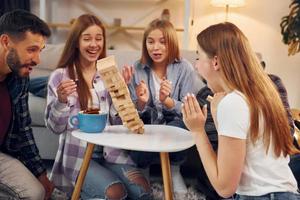 houten toren heeft gevallen. groep van vrienden hebben partij binnenshuis samen foto