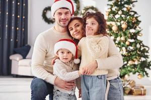 in Kerstmis hoeden. familie vieren nieuw jaar met hun kinderen Bij huis foto