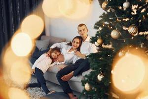 met Kerstmis boom. gelukkig familie vieren vakantie binnenshuis samen foto