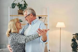 dansen in de huiselijk kamer. senior Mens en vrouw is samen Bij huis foto