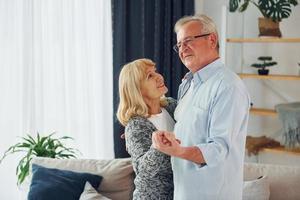 dansen in de huiselijk kamer. senior Mens en vrouw is samen Bij huis foto