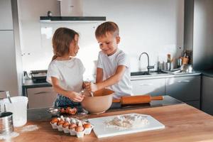 voorbereidingen treffen voedsel samen. weinig jongen en meisje Aan de keuken foto