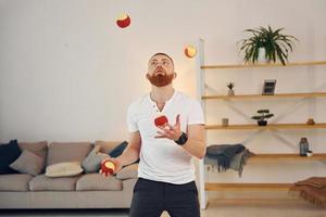 een Mens in gewoontjes kleren gooit ballen Bij huis foto