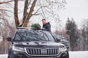 voorbereidingen treffen voor de weekend. Mens met weinig groen Spar is buitenshuis in de buurt zijn auto. opvatting van vakantie foto