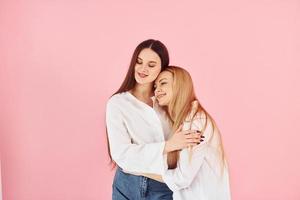 omarmen elk ander. jong moeder met haar dochter staand in de studio foto