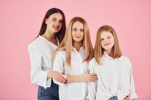 staand samen. jong moeder met haar twee dochters is in de studio foto