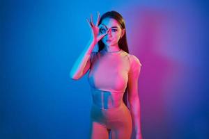geschiktheid lichaam type. modieus jong vrouw staand in de studio met neon licht foto