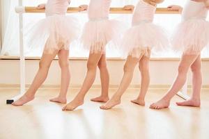 dichtbij omhoog visie. weinig ballerina's voorbereidingen treffen voor prestatie door beoefenen dans beweegt foto