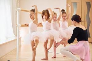 beoefenen houding. weinig ballerina's voorbereidingen treffen voor prestatie foto