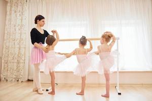 weinig ballerina's voorbereidingen treffen voor prestatie door beoefenen dans beweegt foto