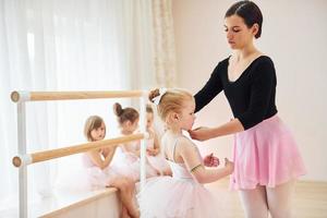 vaststelling houding. weinig ballerina's voorbereidingen treffen voor prestatie door beoefenen dans beweegt foto