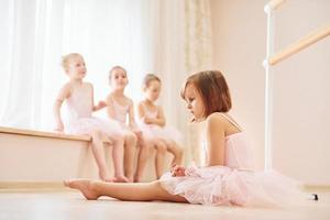 beoefenen Aan de vloer. weinig ballerina's voorbereidingen treffen voor prestatie foto