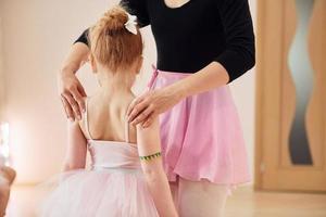 vaststelling houding. weinig ballerina's voorbereidingen treffen voor prestatie door beoefenen dans beweegt foto