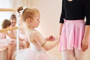 vaststelling houding. weinig ballerina's voorbereidingen treffen voor prestatie door beoefenen dans beweegt foto
