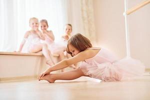 beoefenen Aan de vloer. weinig ballerina's voorbereidingen treffen voor prestatie foto