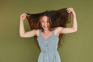 gelaats uitdrukking. jong vrouw in gewoontjes kleren staand binnenshuis in de studio foto