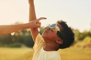 Bij zomer dag samen. twee Afrikaanse Amerikaans kinderen hebben pret in de veld- foto