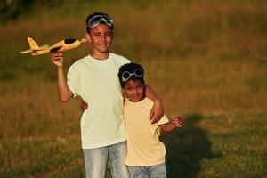 Bij zomer dag samen. twee Afrikaanse Amerikaans kinderen hebben pret in de veld- foto