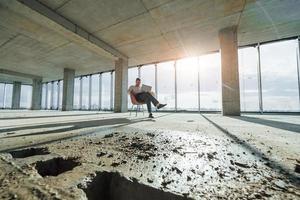 mooi zonlicht gaat door groot venster. jong Mens in formeel slijtage is werken binnenshuis Aan de bouw foto