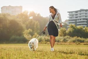 vrouw met haar hond is hebben pret Aan de veld- Bij zonnig dag foto