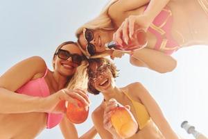 visie van onderstaand. Dames in zwemkleding hebben pret buitenshuis samen Bij zomertijd foto